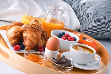 Otel odasındaki bir yatakta kahvaltı tepsisi..