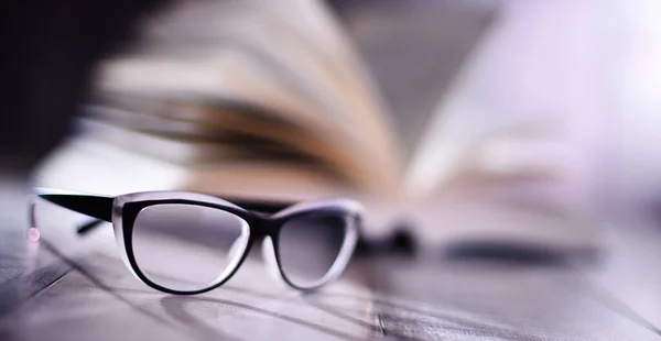 Komposition Mit Brille Und Aufgeschlagenem Buch Auf Dem Tisch — Stockfoto