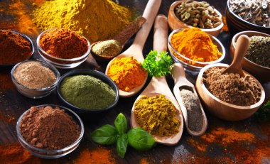 Ahşap mutfak masasında değişik baharatlar var..