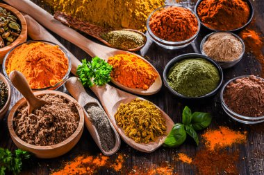 Ahşap mutfak masasında değişik baharatlar var..