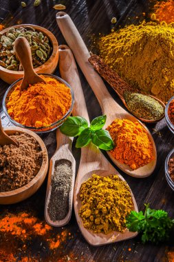 Ahşap mutfak masasında değişik baharatlar var..