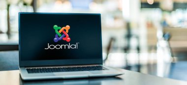 POZNAN, POL - 6 Ocak 2021: Web sitelerinde web içeriği yayınlamak için özgür ve açık kaynak içerik yönetim sistemi (CMS) olan Joomla 'nın logosunu gösteren dizüstü bilgisayar