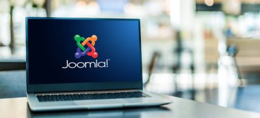 POZNAN, POL - 6 Ocak 2021: Web sitelerinde web içeriği yayınlamak için özgür ve açık kaynak içerik yönetim sistemi (CMS) olan Joomla 'nın logosunu gösteren dizüstü bilgisayar