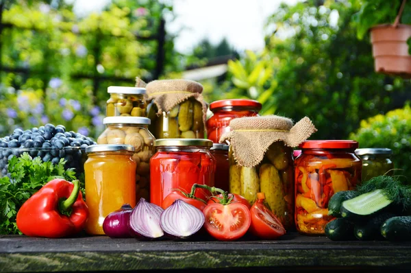 Jars 的腌制蔬菜在花园里。腌制的食品 — 图库照片