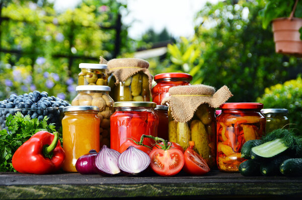 Jars of pickled vegetables in the garden. Marinated food
