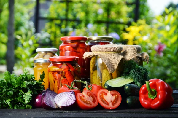 Frascos de verduras en escabeche en el jardín. Alimentos marinados —  Fotos de Stock