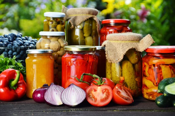 Frascos de verduras en escabeche en el jardín. Alimentos marinados —  Fotos de Stock