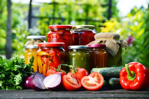 Jars of pickled vegetables in the garden. Marinated food — Stock Image Jars of pickled vegetables in the garden. Marinated food Royalty Free Stock Images