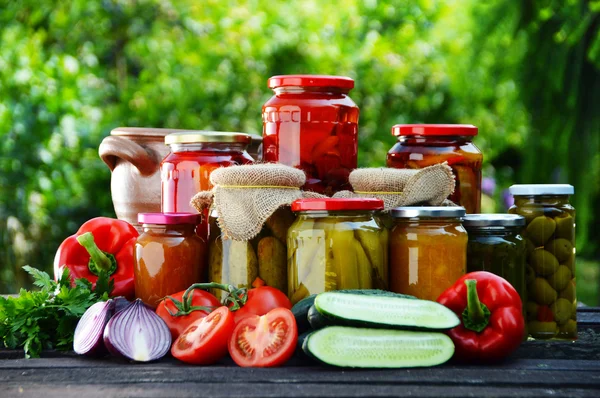 Jars of pickled vegetables in the garden. Marinated food — Stock Image Jars of pickled vegetables in the garden. Marinated food Stock Image