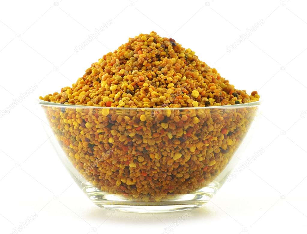 Bowl with bee pollen isolated on white. Nutritional supplement