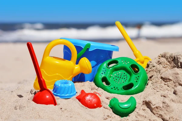 Giocattoli di plastica per bambini sulla spiaggia di sabbia — Foto Stock