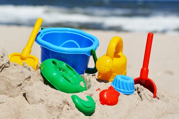 Giocattoli di plastica per bambini sulla spiaggia di sabbia — Foto Stock