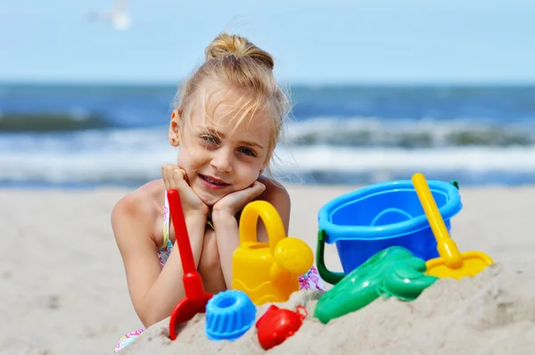 Little girl playing on the sand beach — Stock Photo, Image