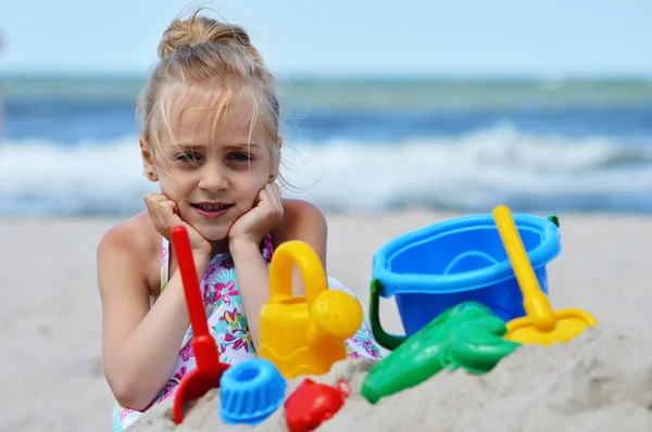 Little girl playing on the sand beach — Stock Photo, Image