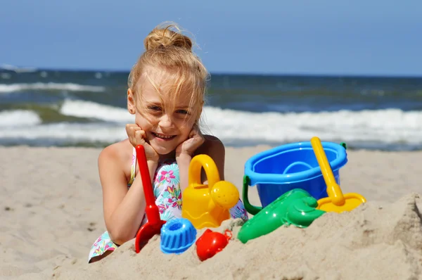 Little girl playing on the sand beach — Stock Photo, Image