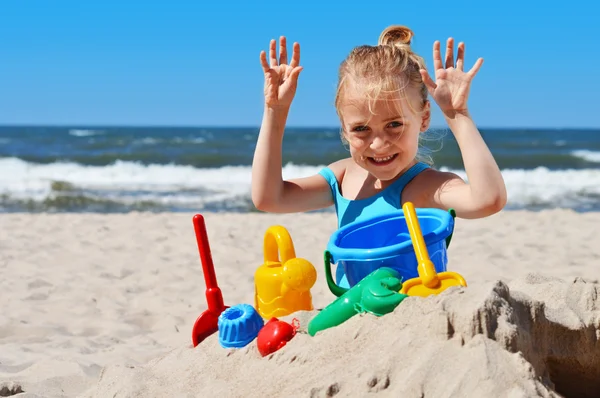 Little girl playing on the sand beach — Stock Photo, Image