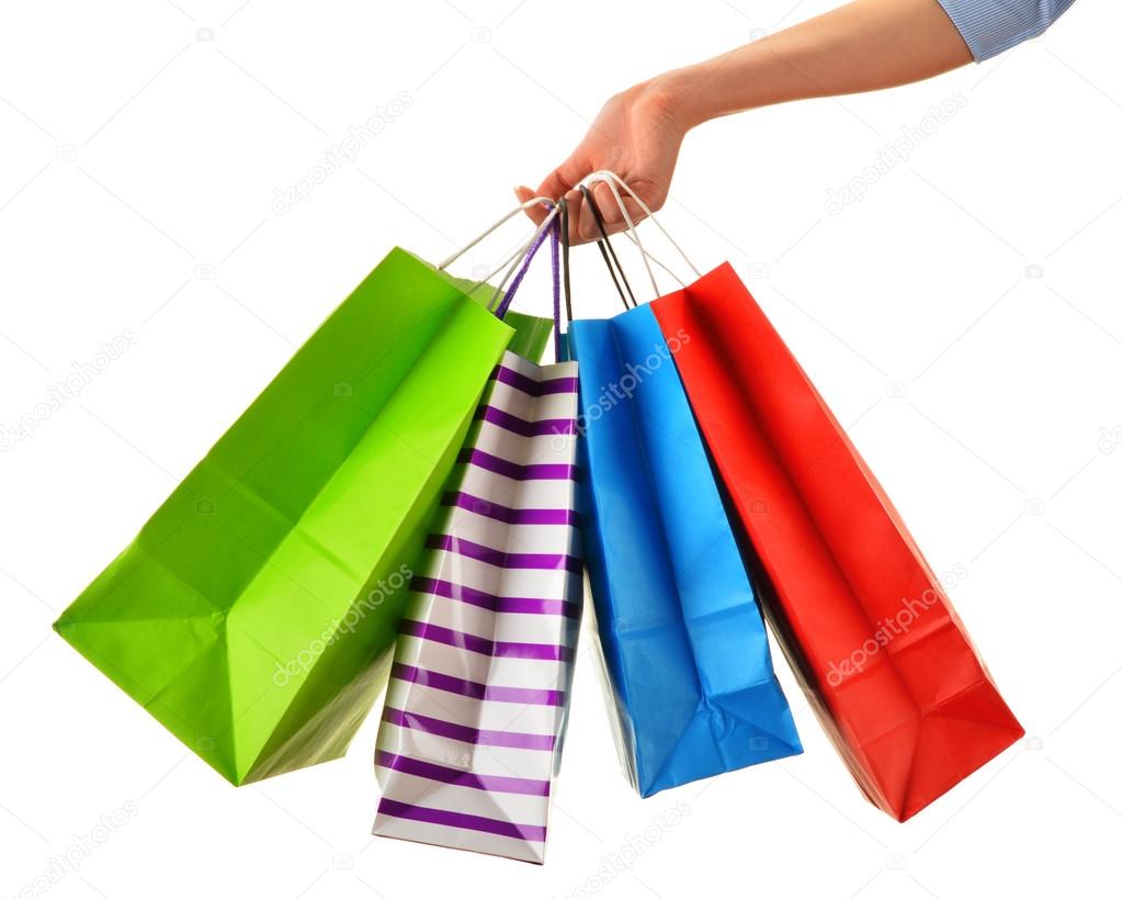 Female hand holding paper shopping bags isolated on white