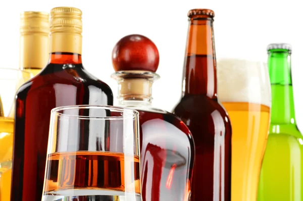 Bottles and glasses of assorted alcoholic beverages over white — Stock Photo, Image