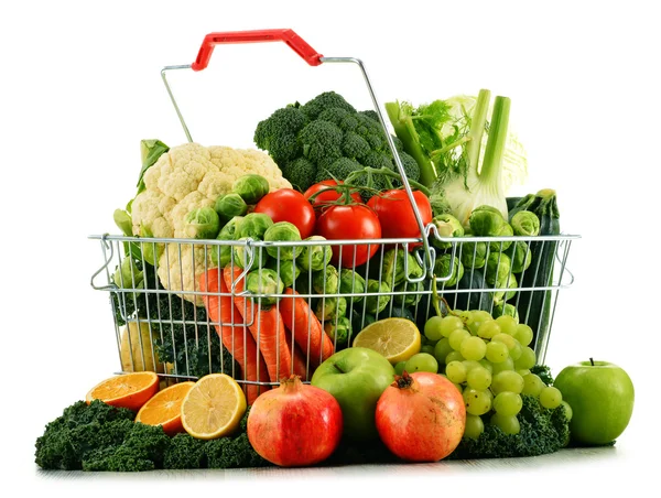 Cesta de la compra con variedad de verduras orgánicas crudas sobre blanco — Foto de Stock