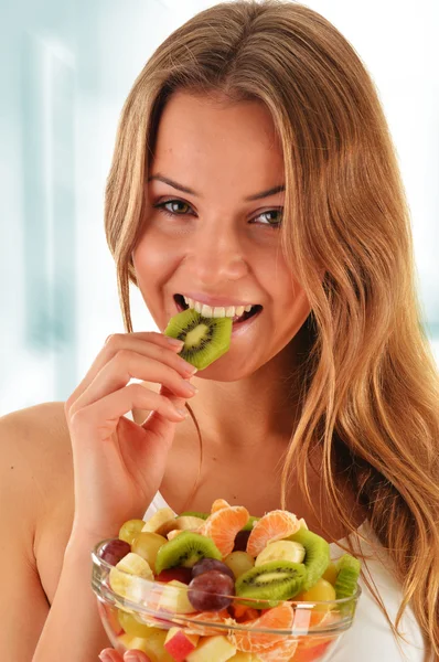 Mujer joven comiendo ensalada de frutas —  Fotos de Stock