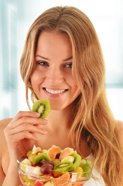 Mujer joven comiendo ensalada de frutas —  Fotos de Stock