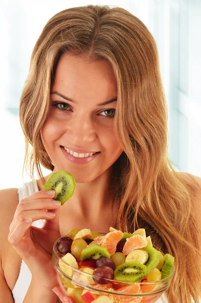 Jovem mulher comendo salada de frutas — Fotografia de Stock