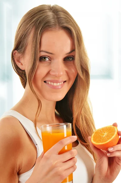 Jovem mulher segurando vidro de suco de laranja — Fotografia de Stock