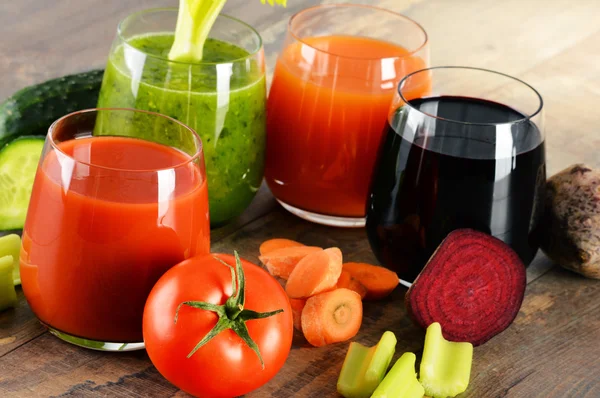 Glazen met verse biologische groentesappen op houten tafel — Stockfoto