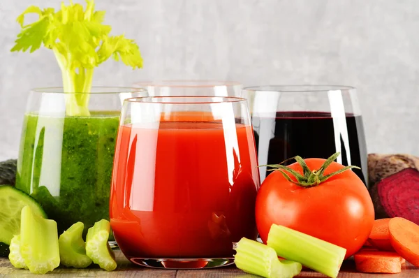 Glasses with fresh organic vegetable juices on wooden table — Stock Photo, Image