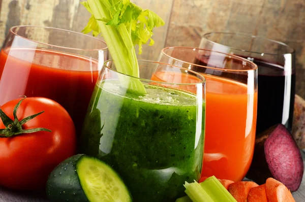 Очки со свежими органическими овощными соками на деревянном столе — стоковое фото