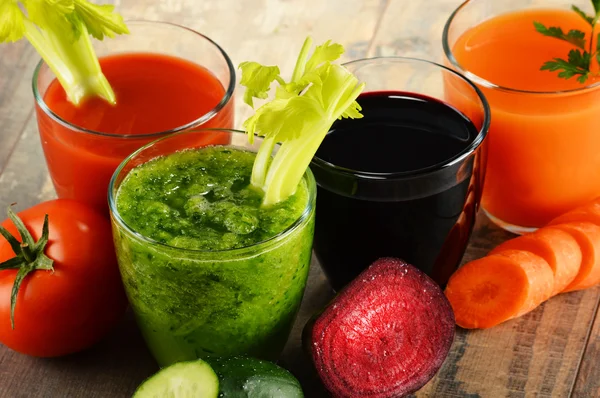 Glasses with fresh organic vegetable juices on wooden table — Stock Photo, Image