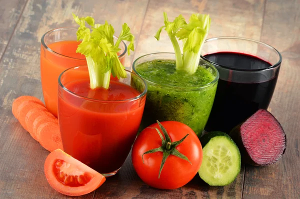 Verres avec jus de légumes frais bio sur table en bois — Photo