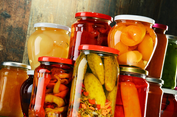 Jars with pickled vegetables, fruity compotes and jams isolated 