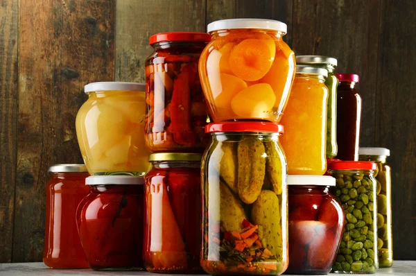 Jars with pickled vegetables, fruity compotes and jams isolated — Stock Photo, Image