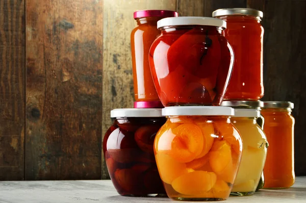 Jars with pickled vegetables, fruity compotes and jams isolated — Stock Photo, Image