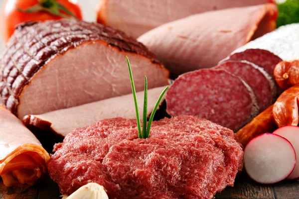 Produtos à base de carne variados, incluindo presunto e salsichas — Fotografia de Stock