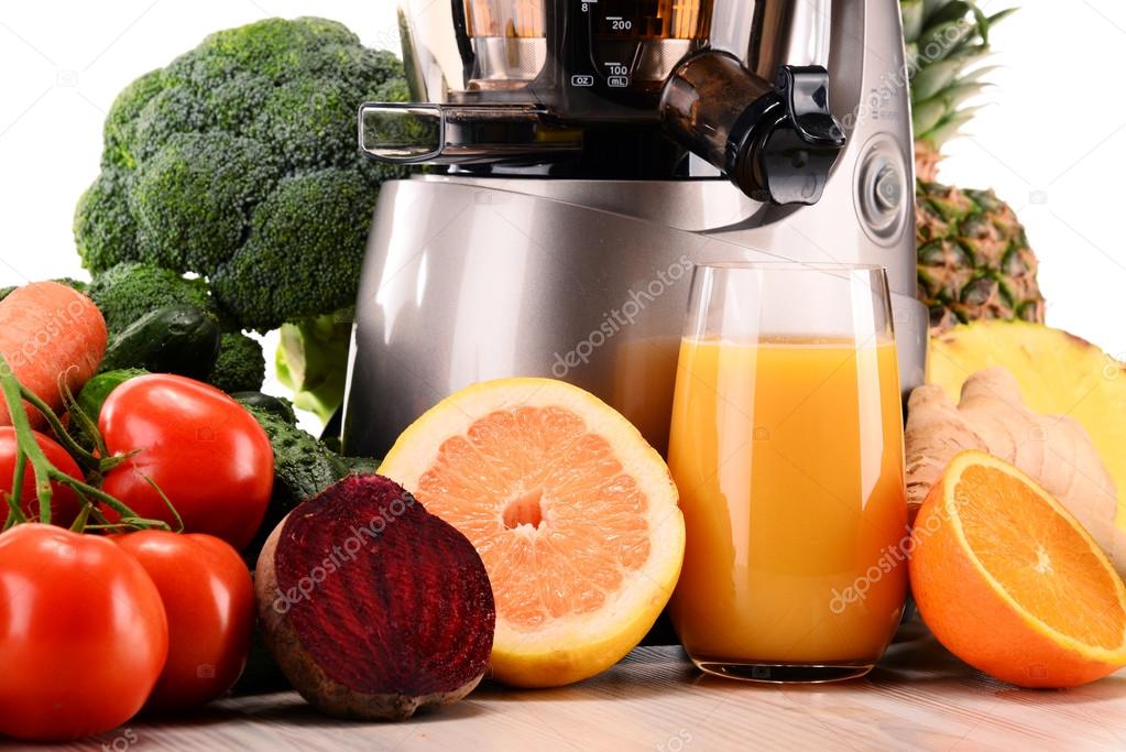 Slow juicer with organic fruits and vegetables isolated on white