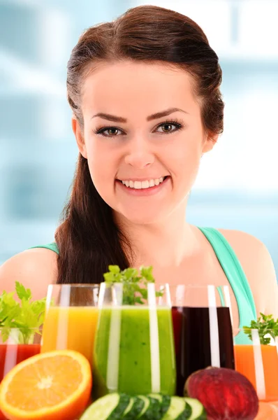 Jeune femme avec variété de jus de légumes et de fruits — Photo