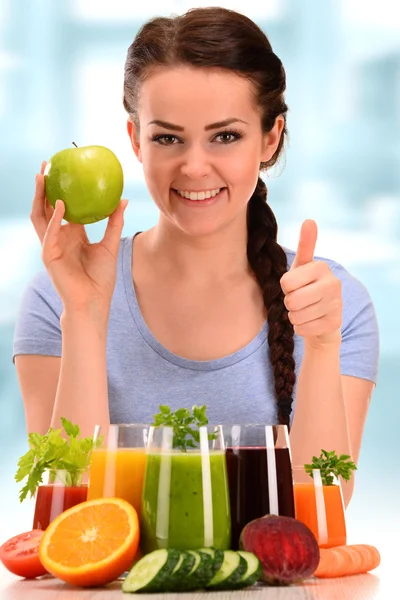 Молодая женщина с различными овощными и фруктовыми соками — стоковое фото