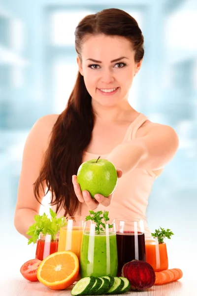 Fiatal nő, zöldség- és gyümölcslevek választékát — Stock Fotó