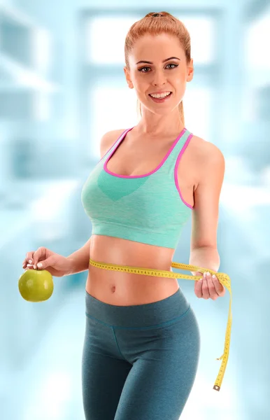Mujer joven sosteniendo cinta métrica y manzana. pérdida de peso —  Fotos de Stock