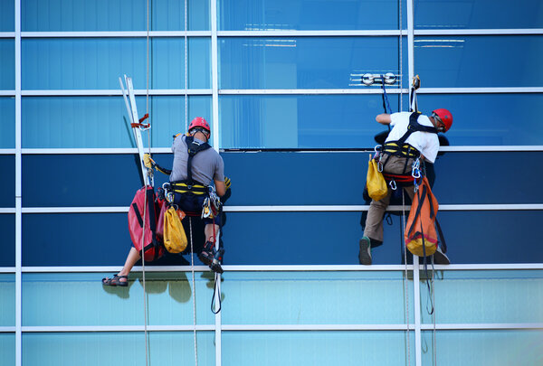Two construction workers working at height on skyscraper 