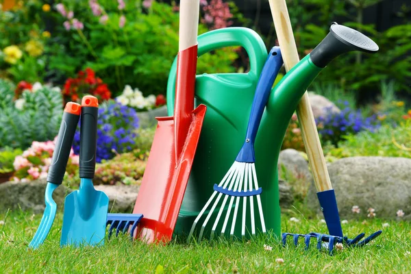 Gieter en gereedschap in de tuin — Stockfoto