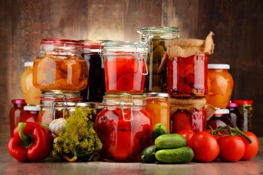 Jars with pickled vegetables and fruity compotes clipart