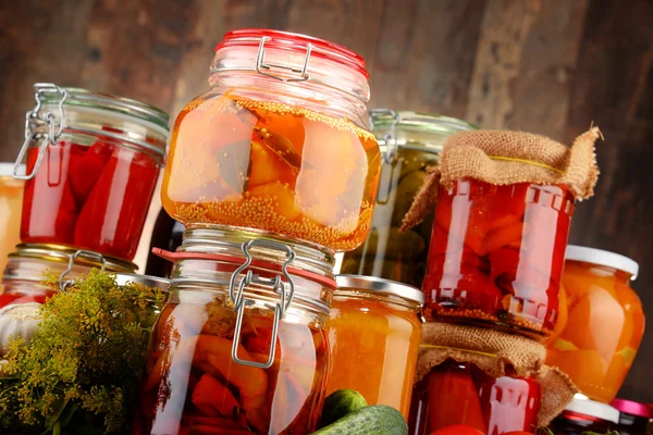 Jars with pickled vegetables and fruity compotes — Stock Photo, Image