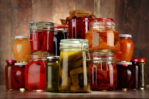 Jars with pickled vegetables and fruity compotes — Stock Photo, Image