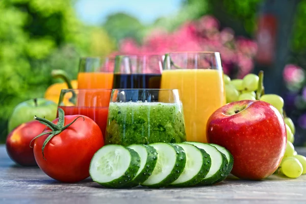 Vasos con zumos de desintoxicación orgánicos frescos en el jardín — Foto de Stock