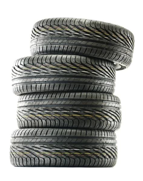 Quatro novos pneus pretos isolados em branco — Fotografia de Stock