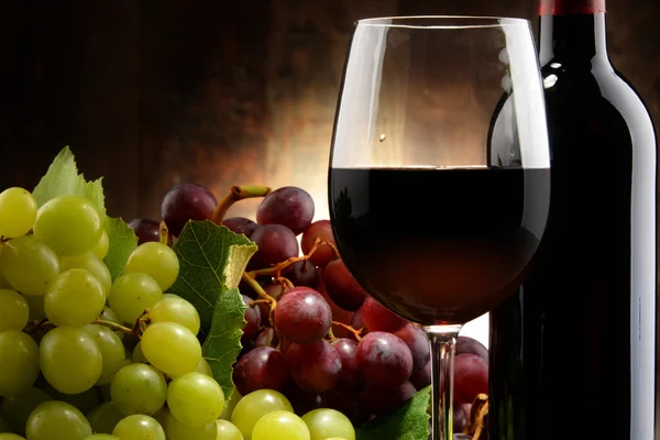 Composition with glass, bottle of red wine and fresh grapes — Stock Photo, Image