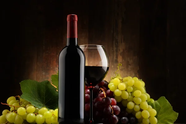 Composition with glass, bottle of red wine and fresh grapes — Stock Photo, Image